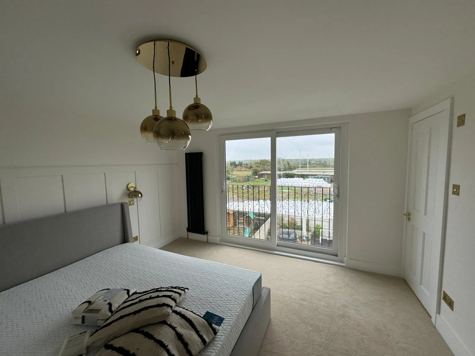 Loft bedroom featuring paneled wall & sliding glass doors