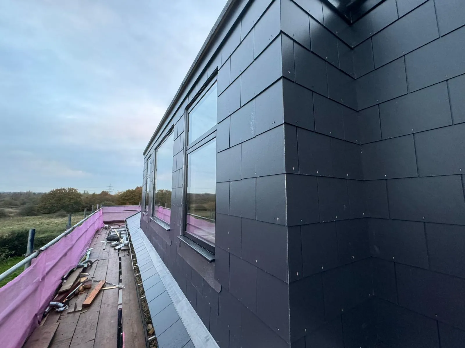 Slate-clad dormer conversion exterior with scaffolding
